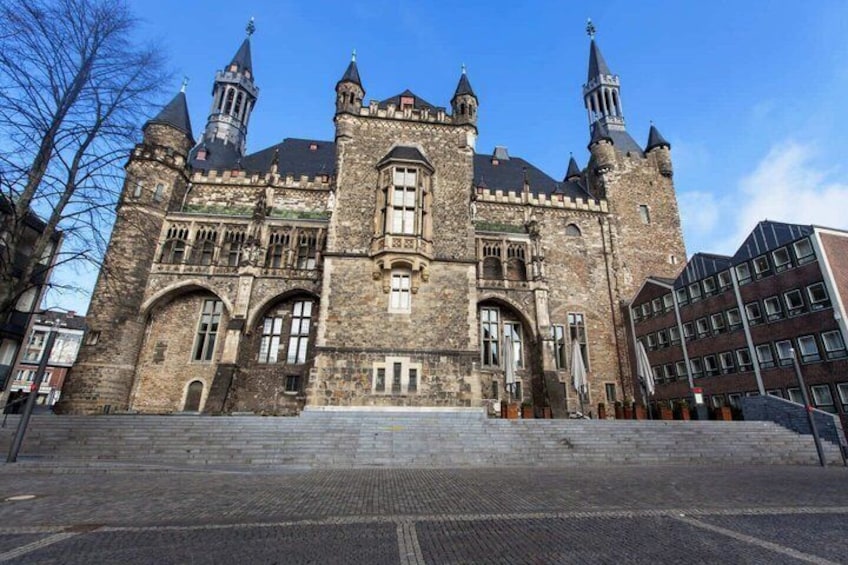 A historic building with a large central tower, arched windows, and a symmetrical facade. 4