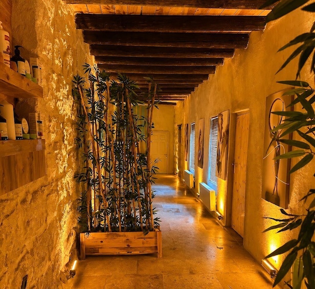 A corridor with wooden beams, a bamboo plant, and shelves with bottles. 4