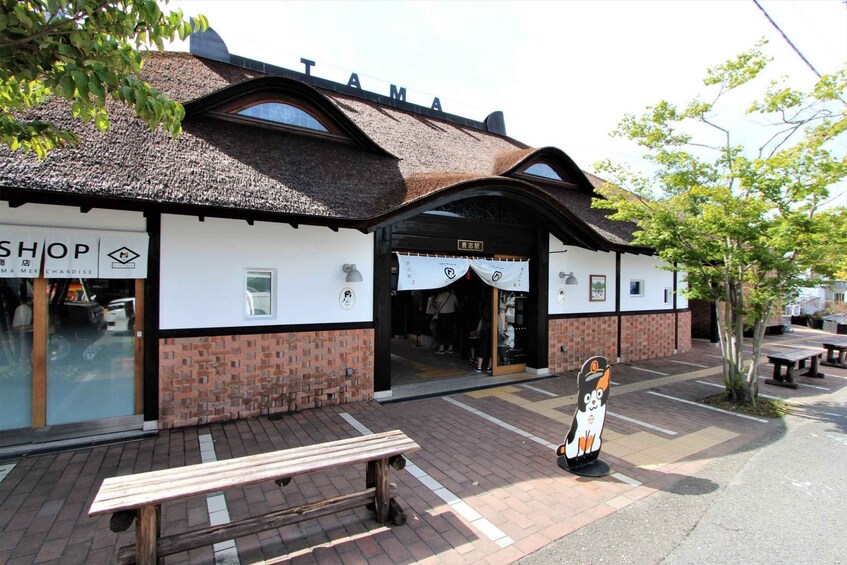 A shop with a thatched roof and a sign reading 'SHOP'. 1
