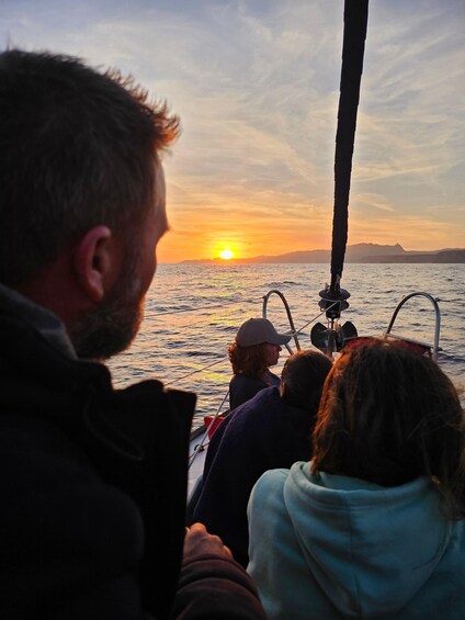 A sunset over the ocean with a boat and people on board. 4