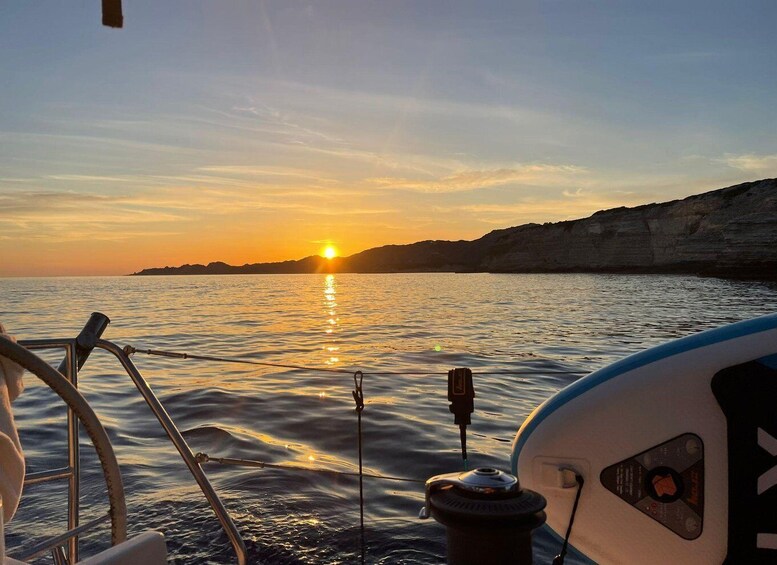 A sunset over a calm sea with a boat in the foreground. 3