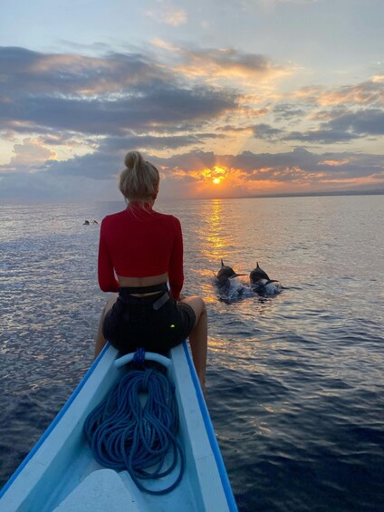 A person in a canoe facing the ocean at sunset. 1