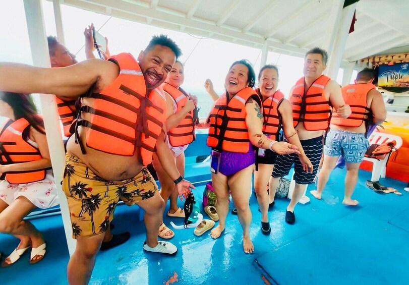 A group of people wearing life jackets on a boat. 1