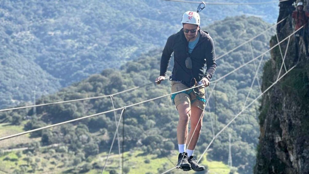 A person on a slackline in a mountainous area. 4