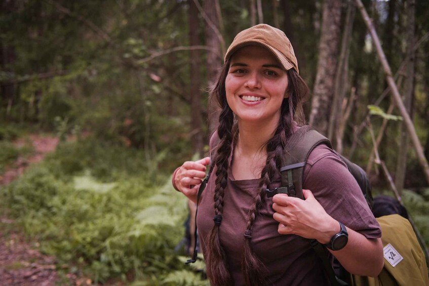 A person hiking in a forest with a backpack and a hat. 3