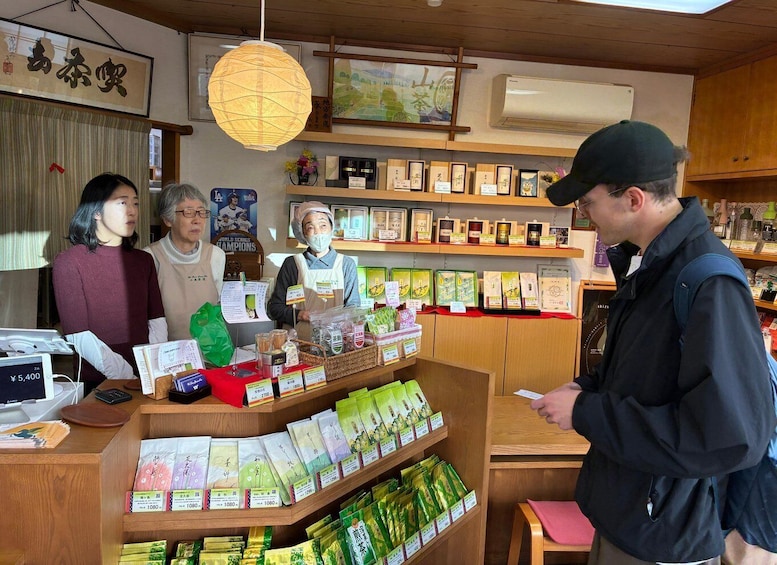 A shop with wooden shelves displaying packaged goods, a cash register, and a hanging paper lantern. 3
