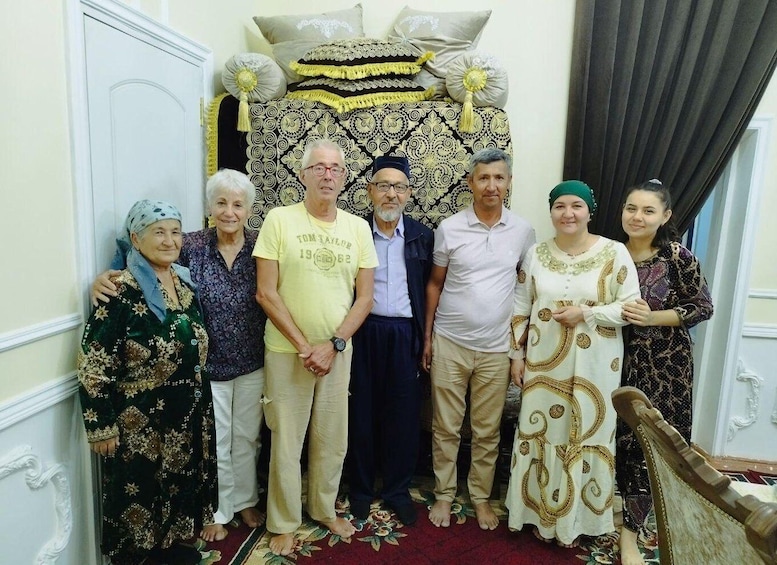 A group of people standing in a room with a patterned backdrop and a staircase. 3