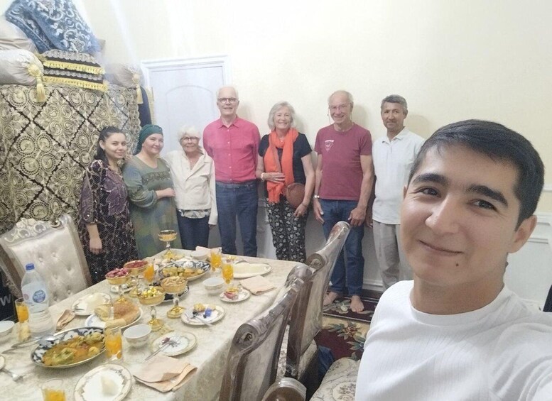 A group of people gathered around a table with various dishes and drinks. 5