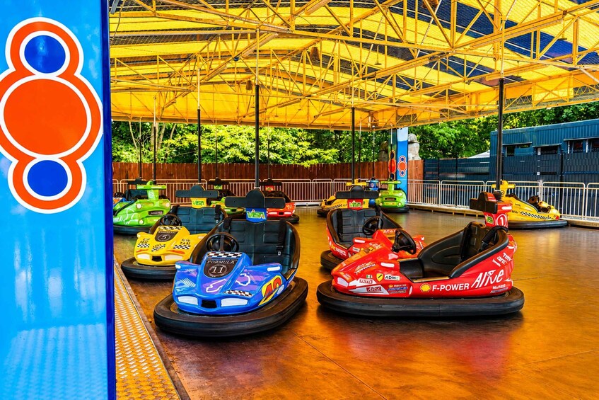 A bumper car ride with colorful cars and a yellow canopy overhead. 2