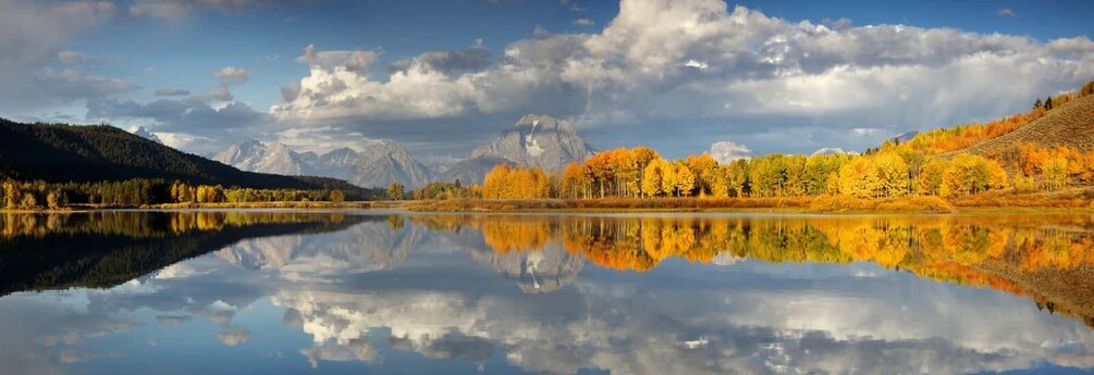 A calm lake reflecting trees and mountains. 2