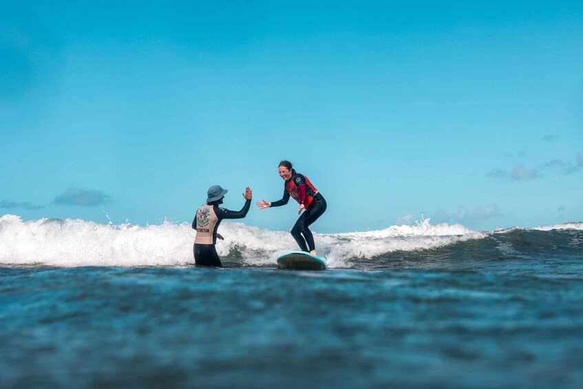Two people surfing on a wave in the ocean. 1