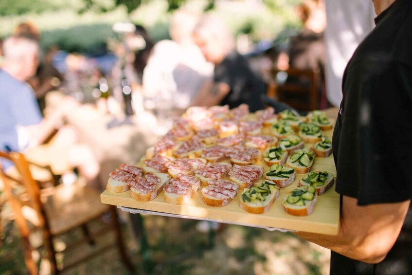A wooden board with various food items, likely at an outdoor event. 5