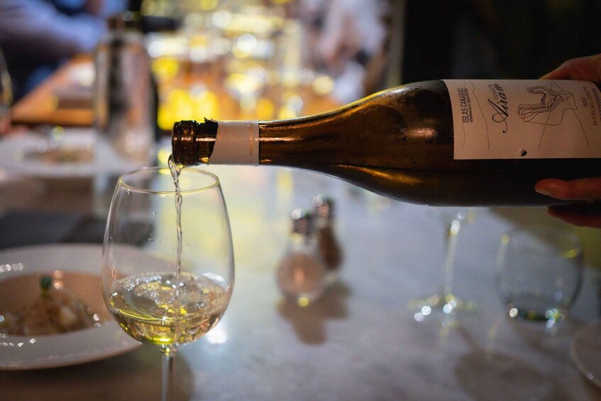 A bottle of wine being poured into a glass. 1