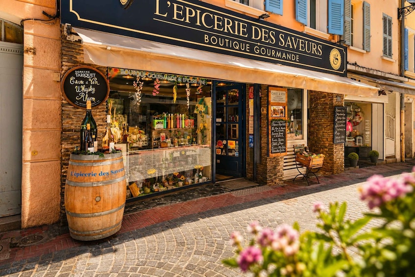 A storefront with a sign reading 'L'Epicerie des Saveurs Boutique Gourmande.' 3