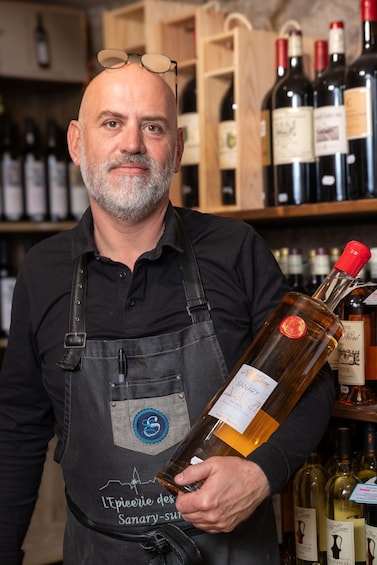 A man holding a bottle of wine with a label that reads 'Riesling.' 2