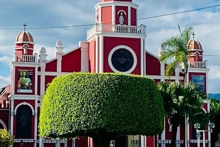 A red church with a dome and a bell tower. 5