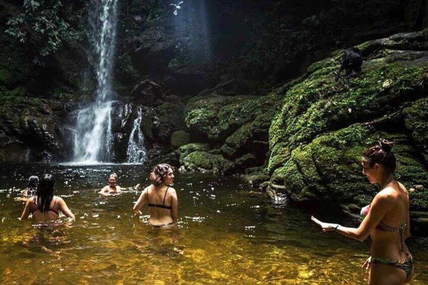A waterfall, clear water, and people in a natural setting. 4