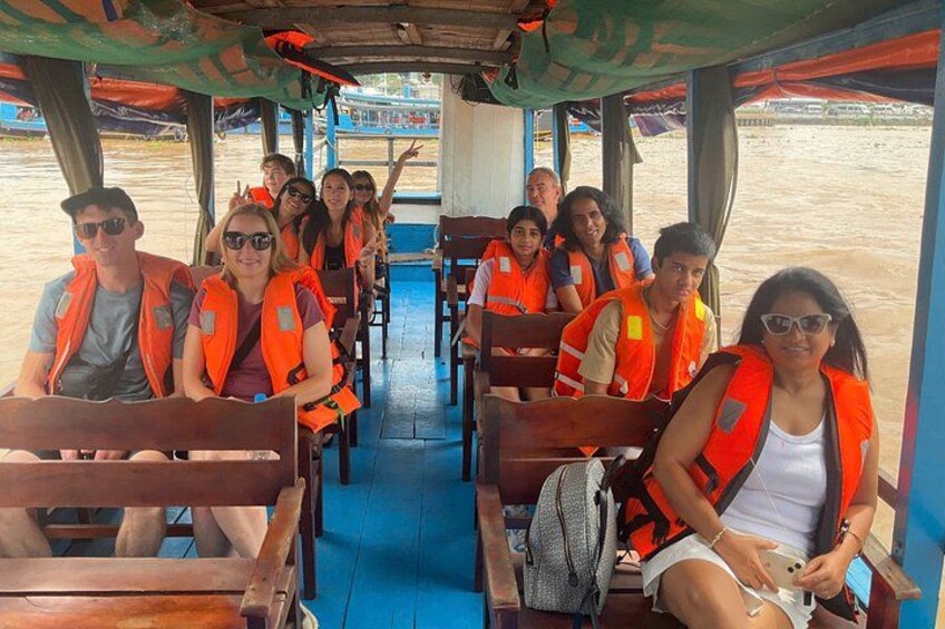 People on a boat wearing life jackets. 2