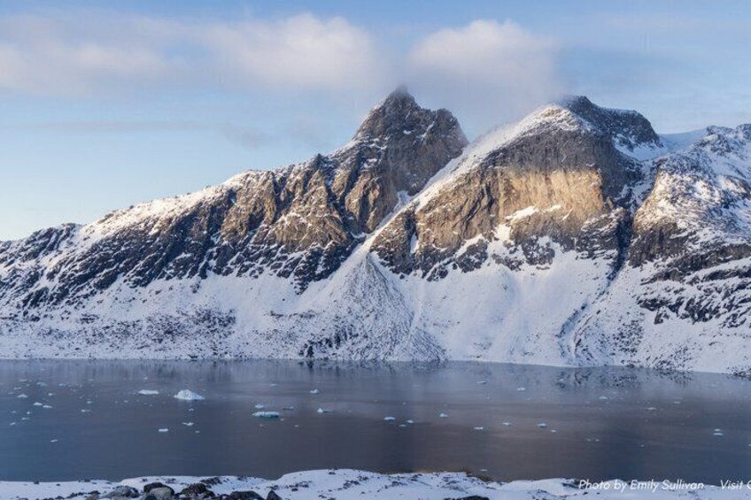 A mountainous landscape with a lake and snow-covered peaks. 4