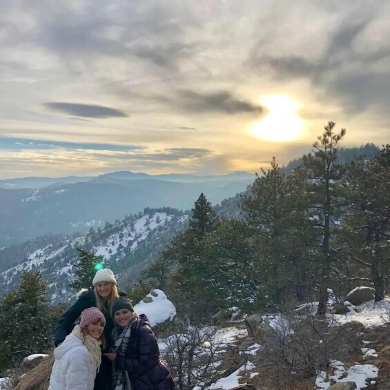 A group of people on a snowy mountain with a sunset in the background. 3