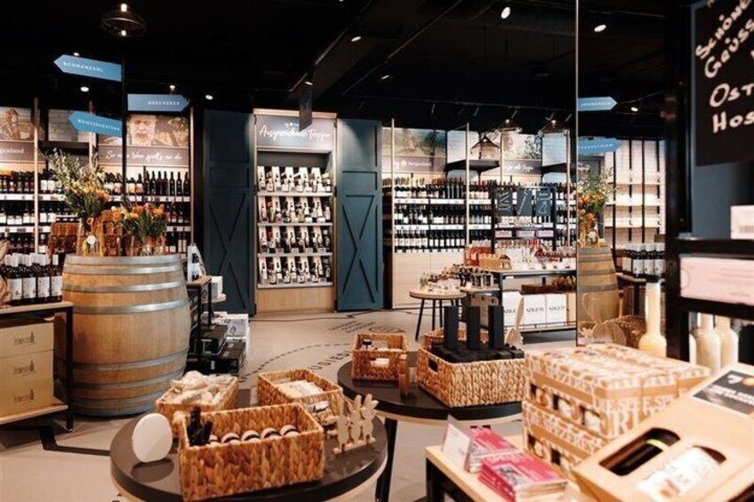 A wine store with shelves of bottles, wooden barrels, and wicker baskets. 3