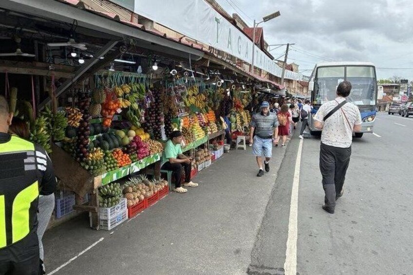 A street market with various fruits and vegetables on display. 5