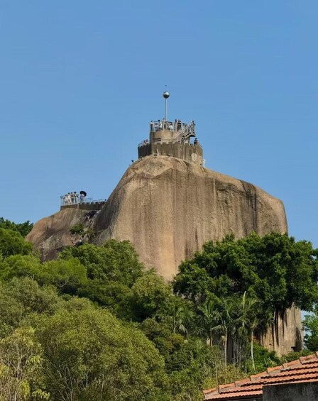 A large rock formation with a viewing platform and a weather station on top. 1