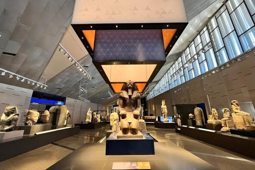 Interior de museo con esculturas de piedra y una vitrina central. 2