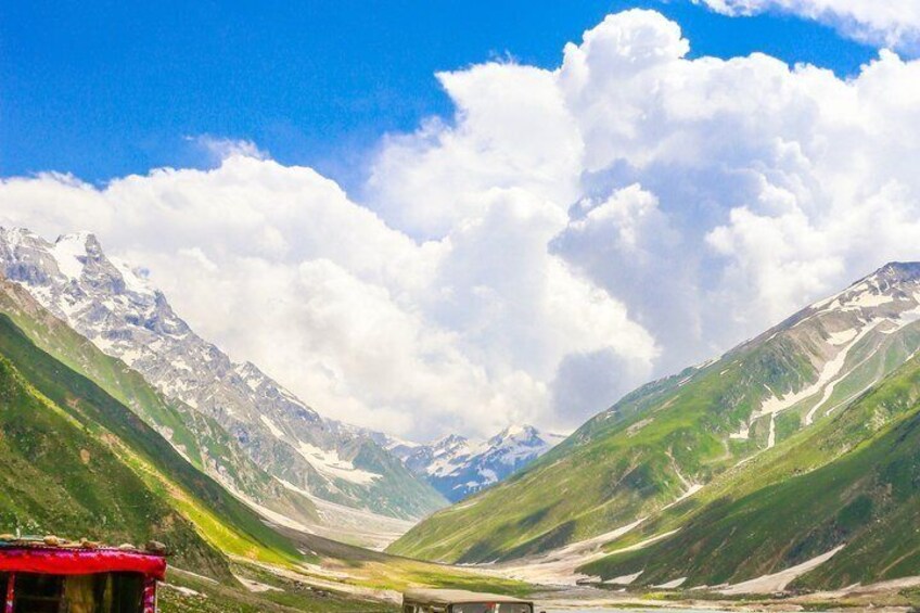 A mountain landscape with a valley, a river, and a red-roofed building. 3