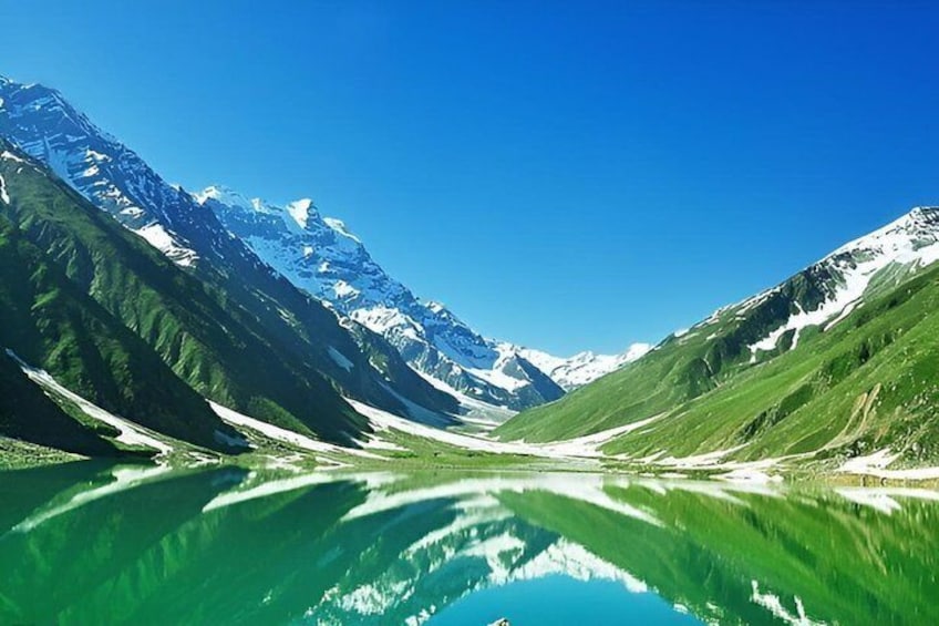 A mountain lake with reflections, surrounded by snow-capped peaks and green valleys. 1