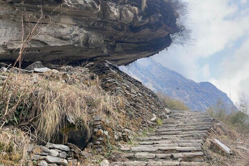 A stone staircase leading up a rocky hillside with a mountain in the background. 4
