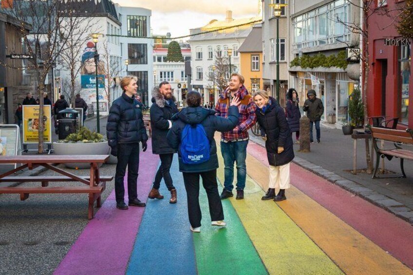 A group of people walking on a colorful pedestrian path in an urban setting with buildings and benches. 5