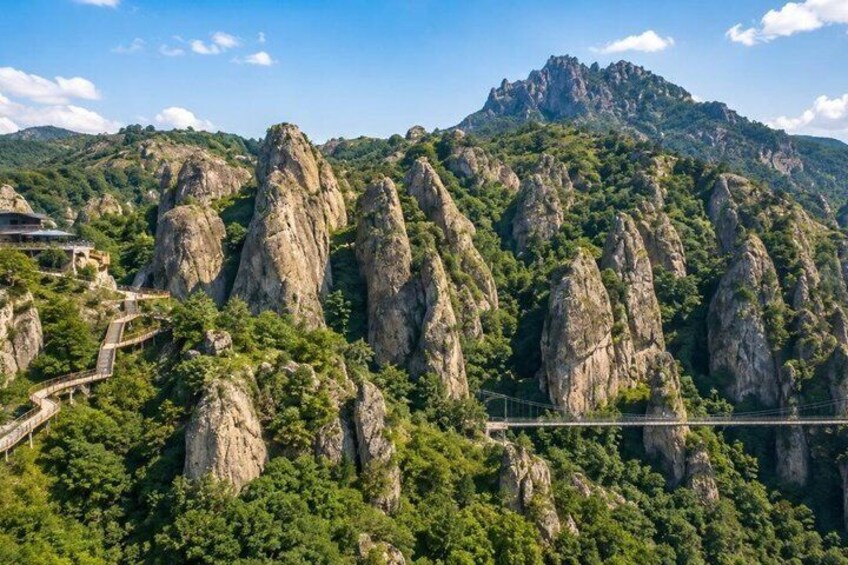 A mountainous landscape with prominent rock formations and a bridge. 4
