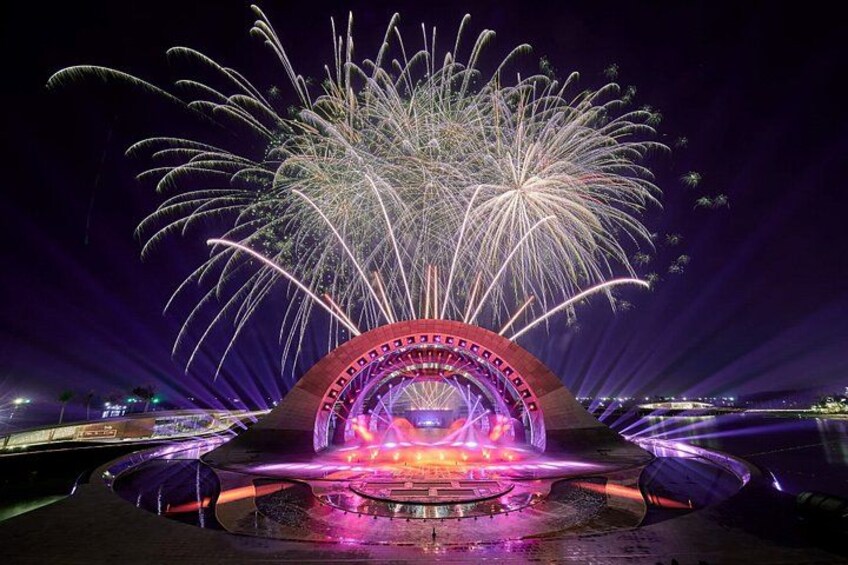 Un spectacle pyrotechnique nocturne avec une structure circulaire et des fontaines d'eau. 3