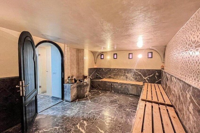A spa with marble floors, wooden benches, and a patterned wall. 3