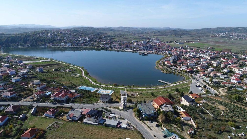 A lake surrounded by a town with houses and roads. 4