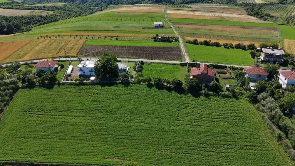 A rural landscape with fields, houses, and a road. 2