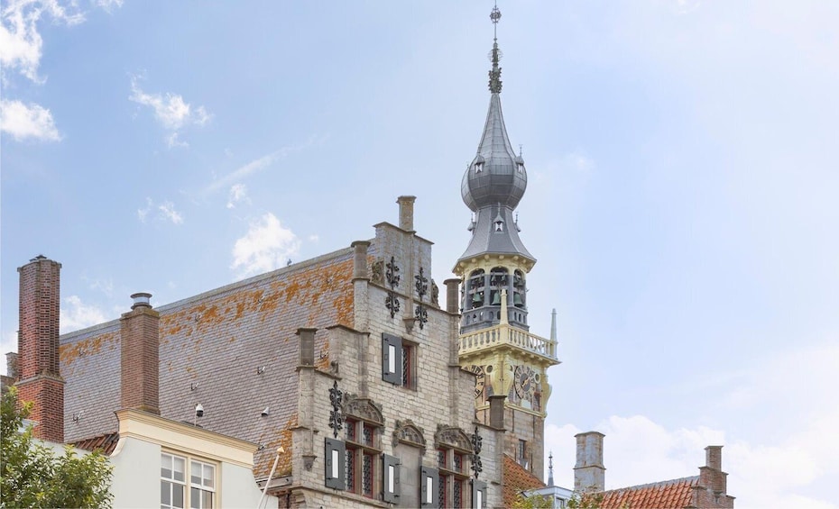 A historic building with a prominent tower, intricate architectural details, and a clear sky. 5