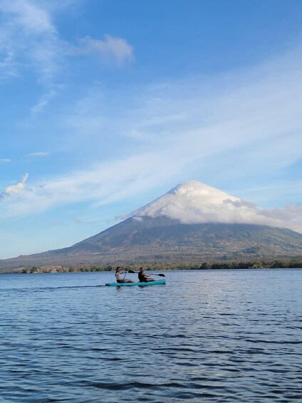 Two people kayaking on a calm lake with a mountain in the background. 4