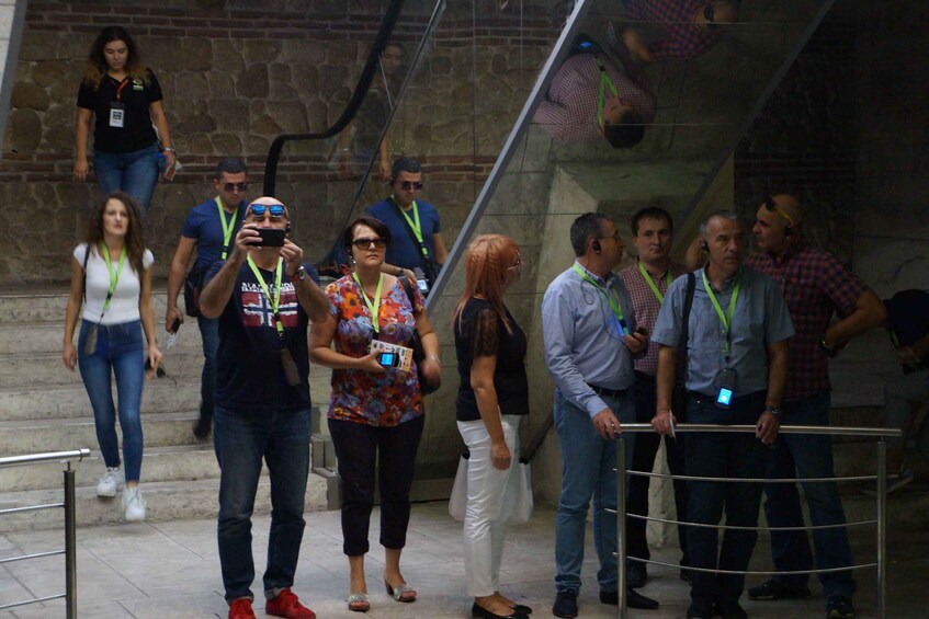 People standing on stairs, some wearing lanyards. 4