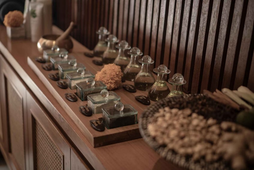A wooden shelf with various glass containers and stones. 5