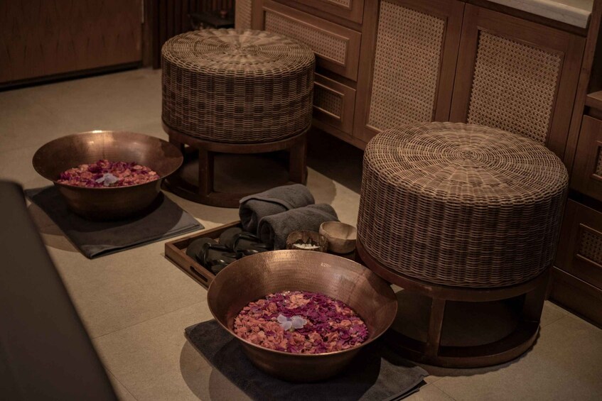 A kitchen with three copper bowls on the floor, each containing pink flower petals. 2