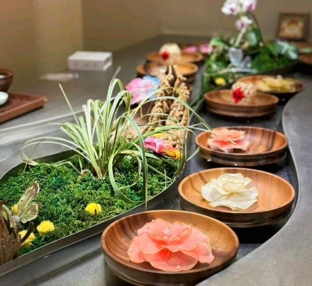 A table with various dishes and decorative elements, including flowers and greenery. 4