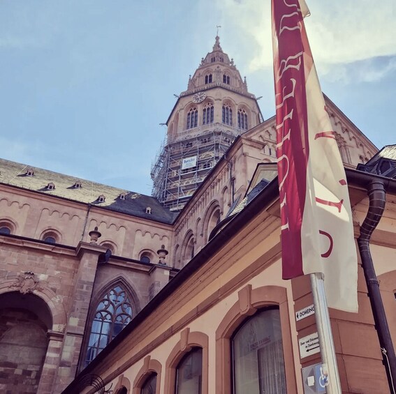 A historic building with a clock tower, a flag, and scaffolding. 4