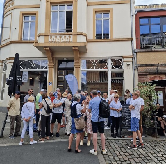 A group of people standing in front of a building with a sign that reads 'A nice place to eat.' 2