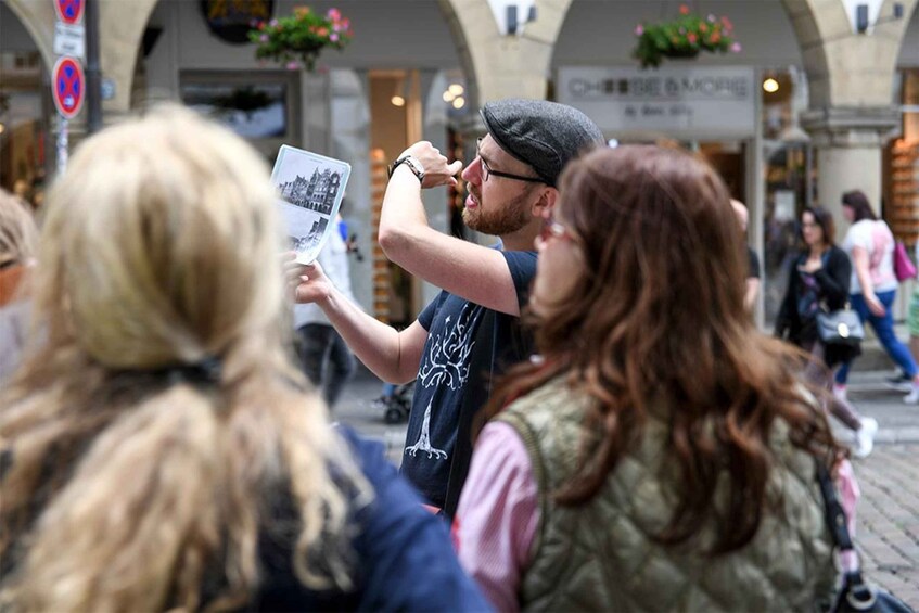 A person taking a photo of another person holding a book. 4