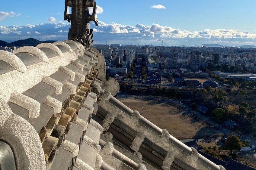 A cityscape with a prominent concrete structure, possibly a monument or part of a building, overlooking a densely populated area with buildings and a clear sky. 5