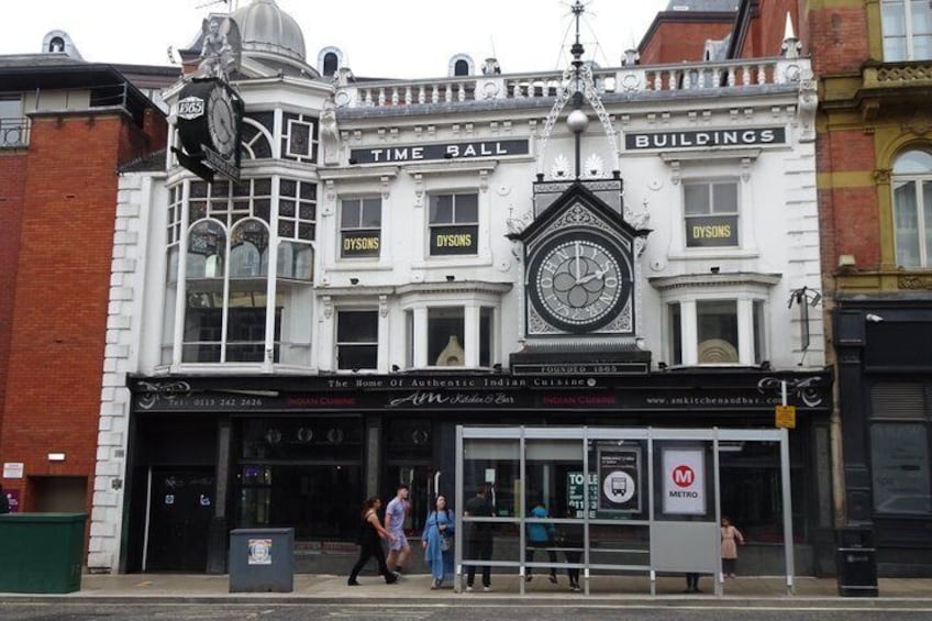 A historic building with a clock, 'Time Hall' sign, and 'Dysons' sign. 2