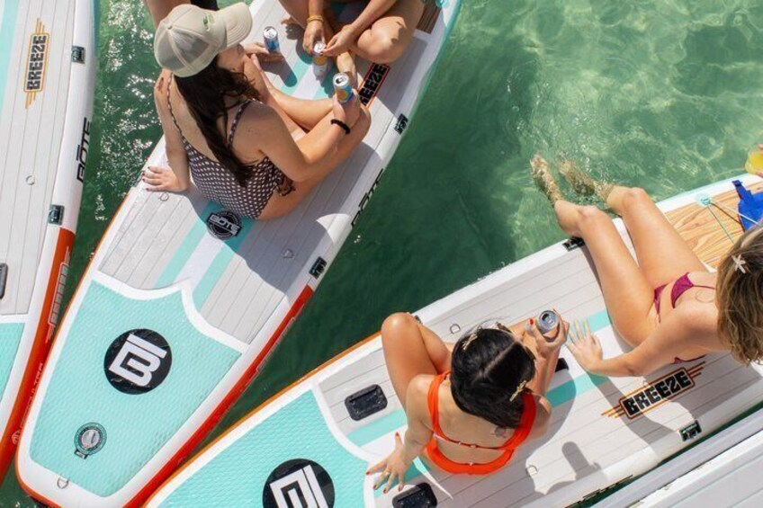 A group of people on a boat with clear water and a logo on the side. 5