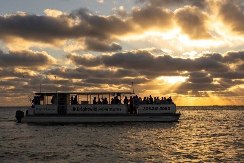A boat with people on board during sunset. 4